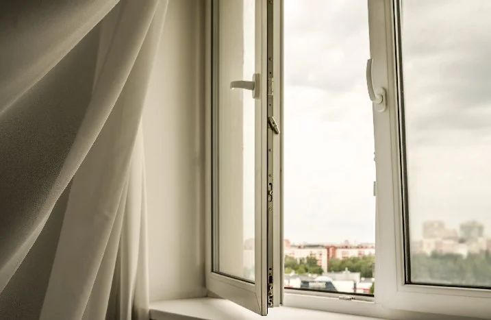 Offenes Fenster mit Blick auf eine Stadt